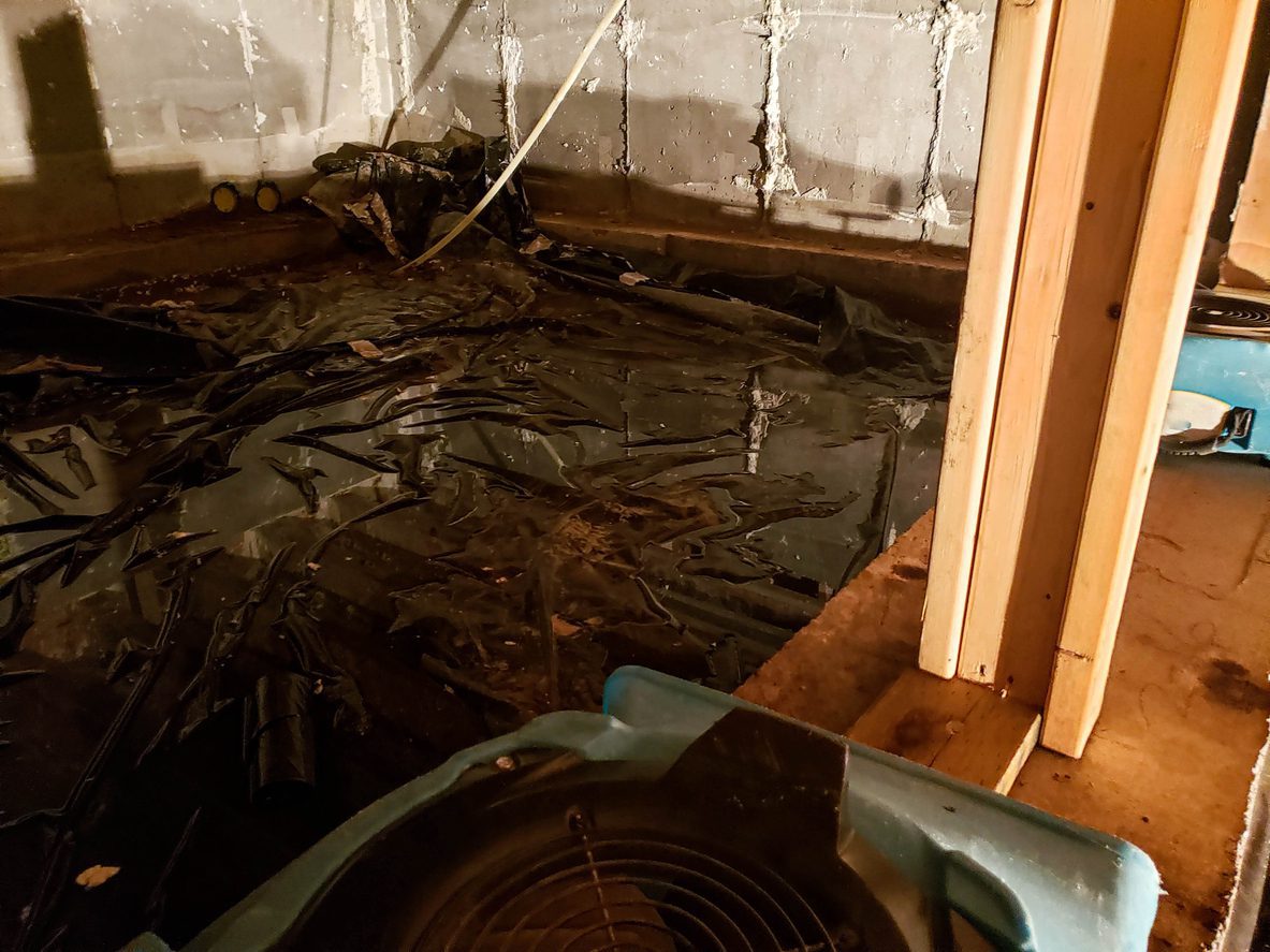 Water laying on top of a vapor barrier with drying equipment placed